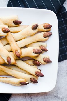 a white plate topped with almonds and pretzels on top of each other