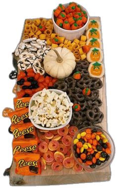 a table topped with lots of different types of candy and candies next to pumpkins