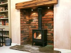 a wood burning stove in a living room next to a bookshelf with shelves