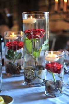 there is a vase with roses in it and rocks on the table next to it