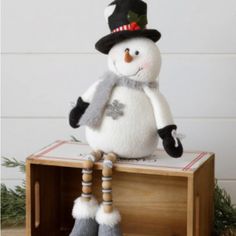 a snowman sitting on top of a wooden crate