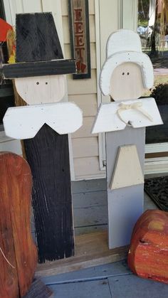 two wooden figures sitting on top of a porch