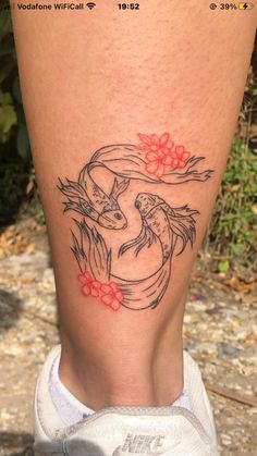 a woman's leg with a tattoo on it that has two birds and flowers