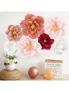 some flowers and balloons are on a shelf next to a wall paper flower art project