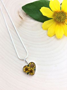 "Sunflowers: Adoration, Happiness, Wealth, and Longevity. Sunflowers are the happiest of flowers! This beautiful Sterling Silver Pendant is handmade with real sunflowers. These flowers are specifically grown to be miniature. They preserve their natural blooming colors and fresh look because of a special drying process. These adorable sunflowers are preserved in resin and encased in Sterling Silver .925. This pendant comes with a FREE Silver Plated Chain. Choose the chain length that you like! ke Valentine's Day Flower Charm Necklace, Handmade Flower Necklace For Valentine's Day, Whimsical Flower Necklace For Gifts, Mother's Day Flower Necklace With Pressed Flowers, Yellow Flower Jewelry For Mother's Day, Flower Shaped Necklace For Valentine's Day, Silver Flower Necklace For Valentine's Day, Yellow Flower Necklaces With Birth Flower Detail, Valentine's Day Flower Necklace With Pressed Flowers