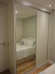 a bedroom with a bed and mirrored closet doors