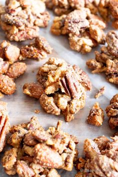 a bunch of cookies that are sitting on a sheet of wax paper with pecans in the background