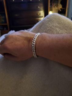 a person's arm with a silver bracelet on it