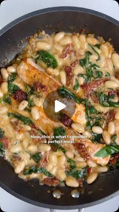 a skillet filled with pasta and spinach on top of a white stovetop