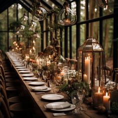 a long table is set with candles, plates and place settings for an outdoor dinner