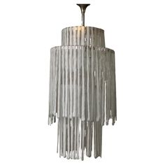 a white chandelier with fringes hanging from it's sides and two lights on each side