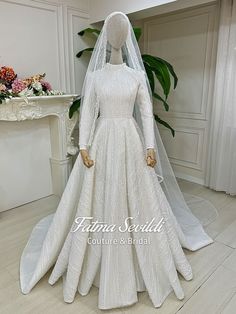 a mannequin wearing a white wedding dress and veil in front of a fireplace