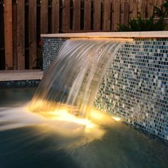 a water fountain in the middle of a swimming pool