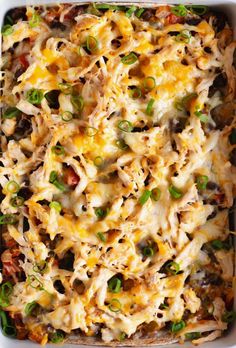 a casserole dish filled with chicken, green onions and cheese in a pan