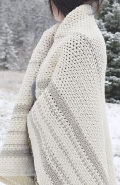 a woman standing in the snow wearing a sweater