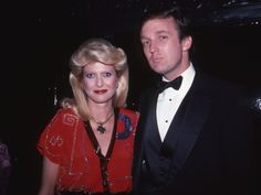 a man in a tuxedo standing next to a woman wearing a red dress