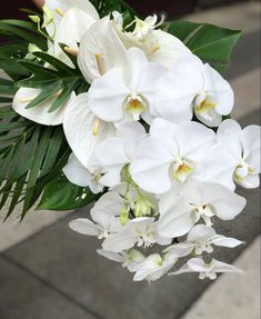 a bouquet of white orchids and palm leaves