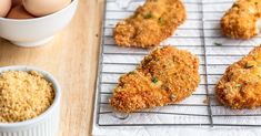 fried chicken on a rack next to eggs and seasoning in small white bowls with spoons