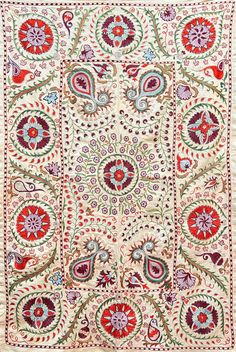 an intricately designed rug with red, green and blue designs on the bottom half