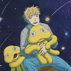 a man sitting on top of a yellow stuffed animal next to two smaller stuffed animals