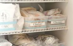 an open refrigerator filled with lots of food and plastic bagged bags on the shelves