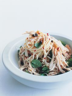 a white bowl filled with pasta and greens