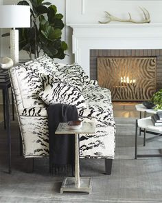 a zebra print chair in front of a fireplace with a black and white blanket on it