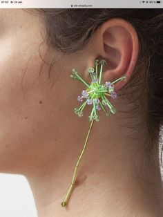 a close up of a person's ear with flowers attached to the back of it