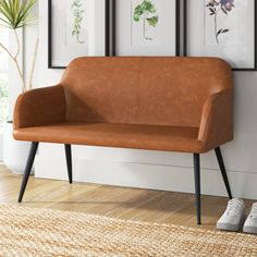 a brown couch sitting on top of a hard wood floor next to a white wall