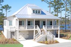 a white two story house with stairs leading up to it