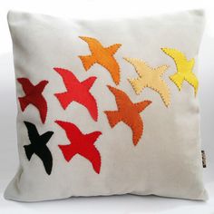 an embroidered pillow with different colored birds on it