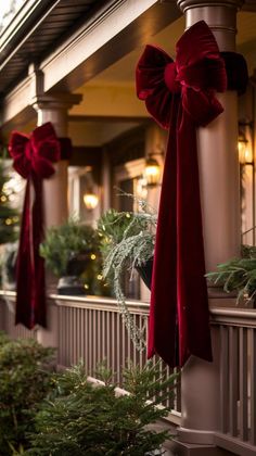 two red bows are hanging on the side of a building with potted plants in front of it