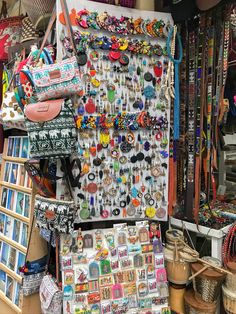 many different items are on display in a market stall, including bracelets and necklaces