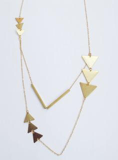 Long Brass Triangle necklace. Double chain necklace in a geometric design. Care: clean brass with a little lemon juice or vinegar Mollie Brown is a small independent fashion label, specialising in handmade clothing and accessories. I design and make everything in my studio in the UK. I source fabrics in small quantities to produce one-off and unique garments. Gold Geometric Minimalist Necklace, Minimalist Gold Geometric Necklace, Gold Geometric Metal Necklace, Minimalist Geometric Gold Necklace, Minimalist Geometric Gold Jewelry, Modern Gold Geometric Necklace, Gold Geometric Brass Jewelry, Gold Geometric Metal Jewelry, Minimalist Geometric Metal Necklace