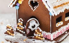 a close up of a gingerbread house with candy on the roof and decorations around it