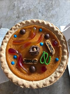 a pie is decorated with candy, pretzels and candies on it's crust