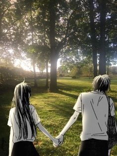 two people holding hands in front of trees and grass with the sun shining behind them