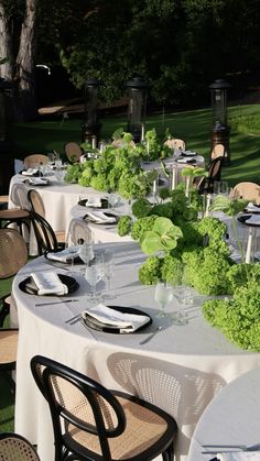 an outdoor dining area with tables, chairs and centerpieces set up for dinner