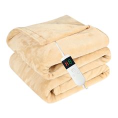 a blanket with an electronic thermometer on it and two blankets folded up next to each other