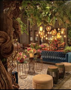 a room filled with lots of furniture and flowers on the walls, along with hanging lights