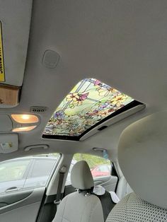 the interior of a car with a sunroof and stained glass window in it