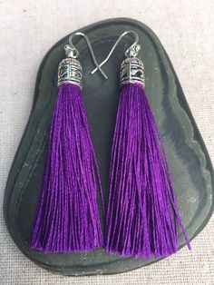 Chic purple tassel earrings!  They would add a pop of color to any outfit for any occasion.  Dress them up or down.  They are timeless and versatile.  They are lightweight, fun and unique!The tassels measure 2 1/8” long by 1/4” wide.  They hang from simple silver ear wire hooks.  Overall drop length is about 2 1/4”.  Metal is allergy free plated silver.These are my latest creation!  I have them available in many colors!  Find them all under the category tassel earrings in my shop.Thanks for stop Gift Purple Tassel Earrings With Dangling Beads, Purple Fringe Tassel Earrings Gift, Purple Dangle Earrings With Tassels, Purple Dangle Jewelry With Tassels, Handmade Bohemian Purple Tassel Earrings, Elegant Purple Tassel Earrings, Purple Dangle Tassel Earrings, Purple Statement Earrings, Silver Boho Jewelry