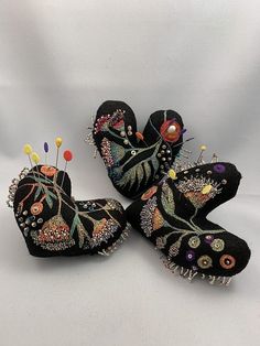 three black birds decorated with colorful pins and beads