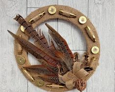 Crafts With Pheasant Feathers, Shotgun Shell Wreath Tutorial, Duck Feather Wreath, Pheasant Decor, Hunting Wreath Rustic, Bullet Shell Crafts, Shotgun Shell Crafts, Hunting Themes