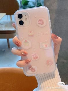 a woman holding up her phone case with stickers on it