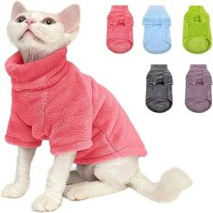 a white cat wearing a pink sweater and four pairs of shoes