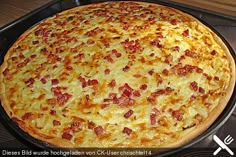 a large cheese pizza sitting on top of a stove