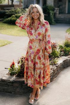 Long sleeve split neck floral print long dress with waist belt and contrast detail in neck, cuffs, and skirt 100% polyester Spring Red Midi Dress With Tie Waist, Spring Bohemian Midi Dress With Belt, Spring Brunch Belted Maxi Dress, Spring Brunch Maxi Dress With Belt, Spring Bohemian Belted Midi Dress, Fall Brunch Belted Maxi Dress, Spring Maxi Dress With Belt For Brunch, Long Sleeve Belted Dress For Vacation, Spring Long Sleeve Maxi Dress With Tie Waist