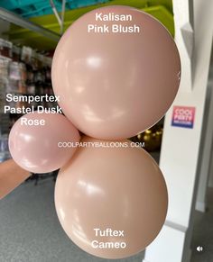 three balloons with names on them hanging from the ceiling in front of a store display