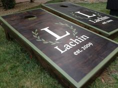 two personalized cornhole game boards sitting in the grass